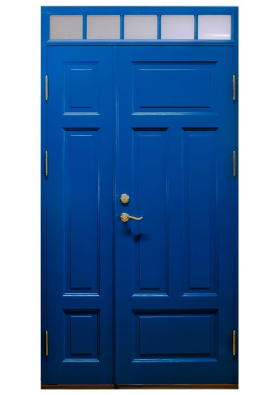 Blå dubbeldörr med klassiska spegelpaneler och mässingsfärgade beslag. Ovanför dörren finns ett överljus med fem smala glasrutor.