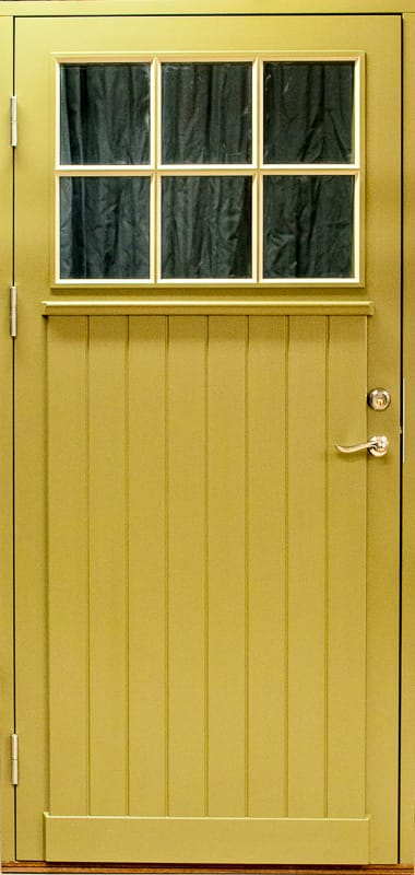 Gul ytterdörr med spröjsat glasfönster upptill och stående träpanel nedtill.