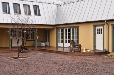 Gårdsfasad med flera spröjsade fönster och dörrpartier i klassisk stil.