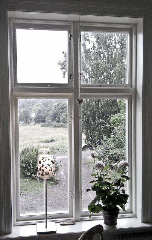 Interiör med två klassiska fönster med tvärpost och spröjs, ljus inramning.