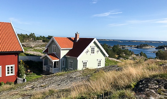 Exteriörvy med hus där fönster och glaspartier ger ljus och tydliga fasaddetaljer, med synliga glasfält i flera rum.