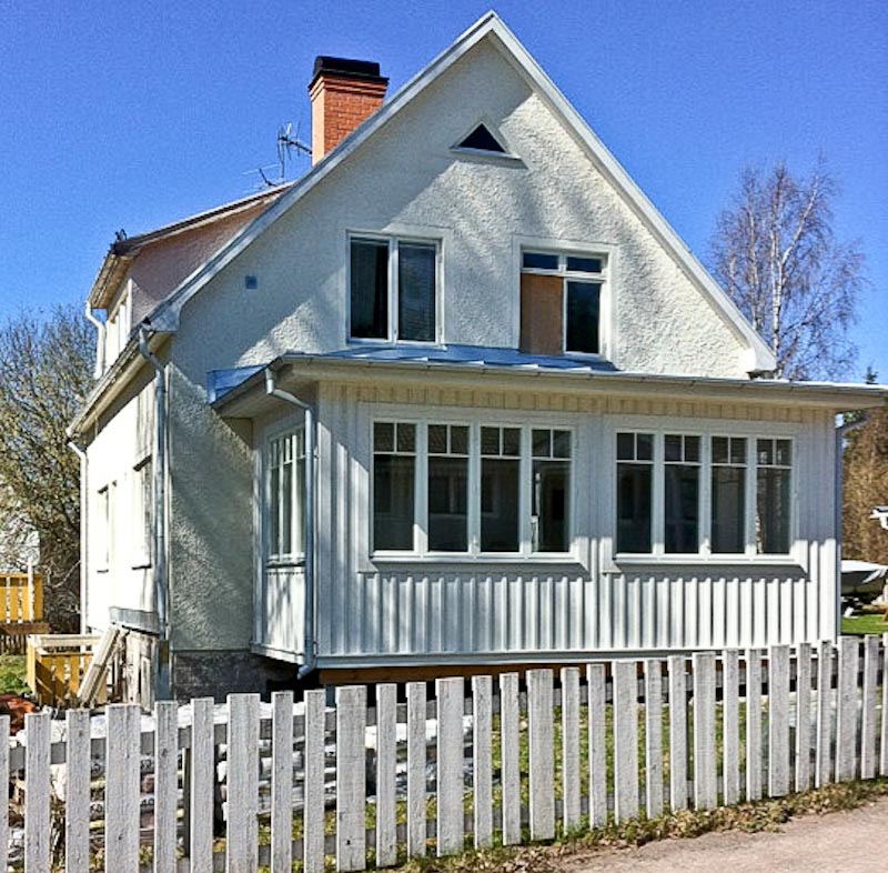 Hus med glasveranda och fönsterrad i klassisk stil.