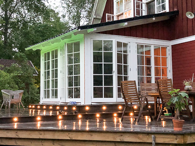 Glasade dörrar med spröjs som lyser i kvällsljus.