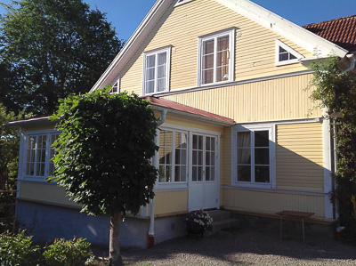 Glasveranda med spröjsade fönster som släpper in mycket ljus.