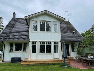 Utbyggnad med glasade dörrar och fönster som ger generöst ljusinsläpp.