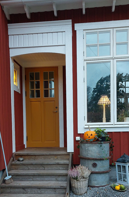 Ytterdörr med glasrutor upptill som släpper in ljus i entrén.