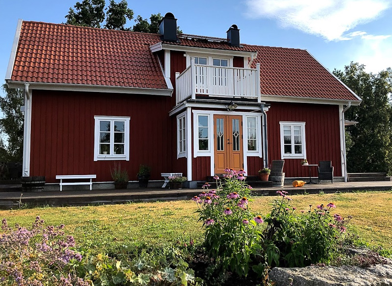 Veranda med glasad dörr och sidofönster som släpper in ljus.
