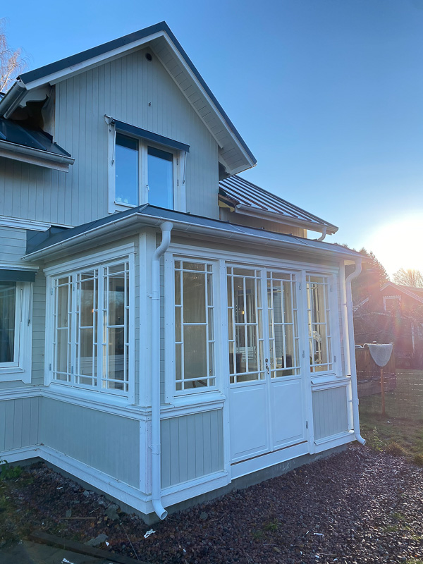 Glasveranda i vinkel med spröjsade fönster och mycket glas för bra ljusinsläpp.