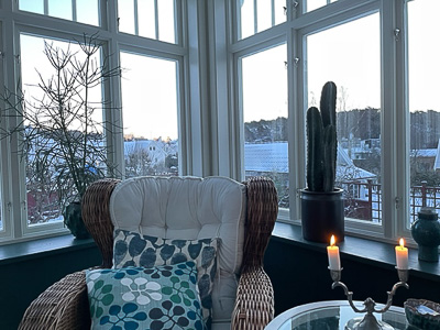Veranda med stora fönster i hörn som ger generöst ljusinsläpp.
