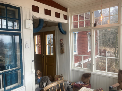 Fönsterpartier i glasveranda med spröjs och stora glasrutor som ger bra ljus.