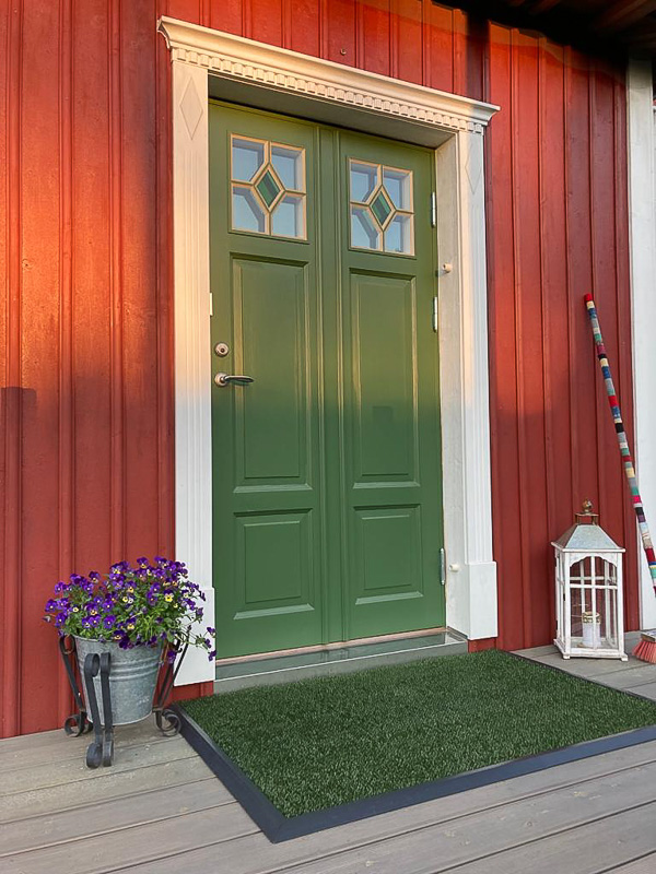 Pardörr med spröjsade glasrutor som ger ljusinsläpp vid entrén.