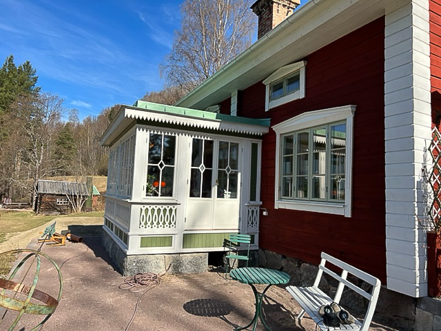 Inglasad veranda med spröjsade fönster och dekorativa glasrutor som ger stort ljusinsläpp