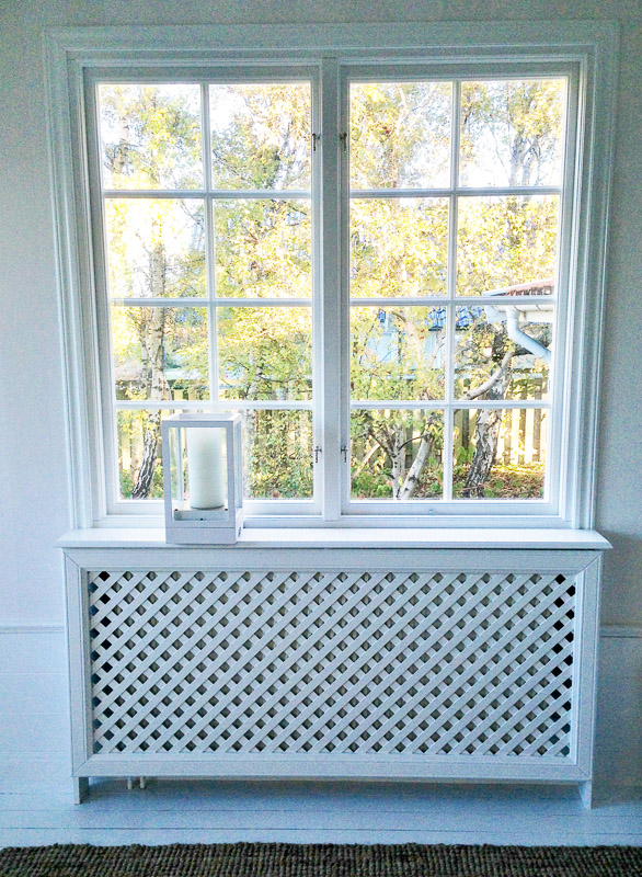 Spröjsat fönster i rutnät ovanför radiatorfront med klassisk gallerfront.