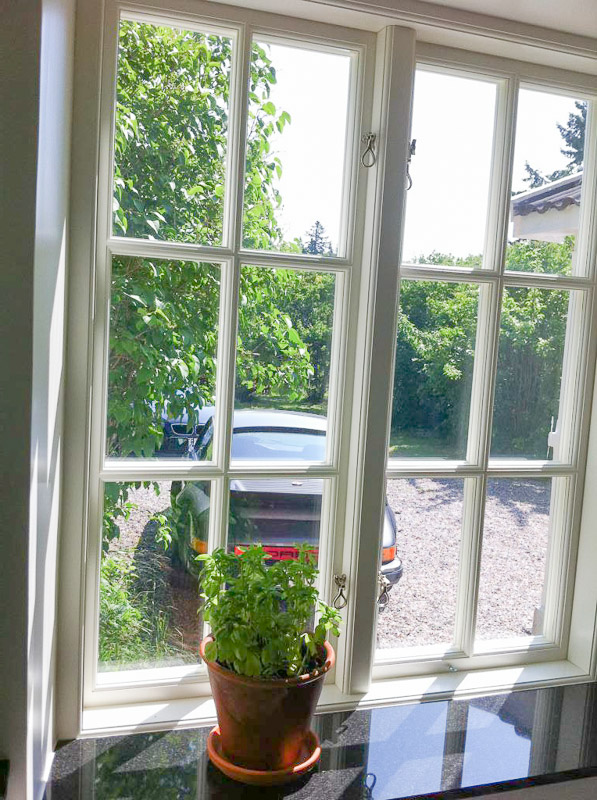 Inomhusvy med spröjsat fönster i rutnät och ljus karm/foder.